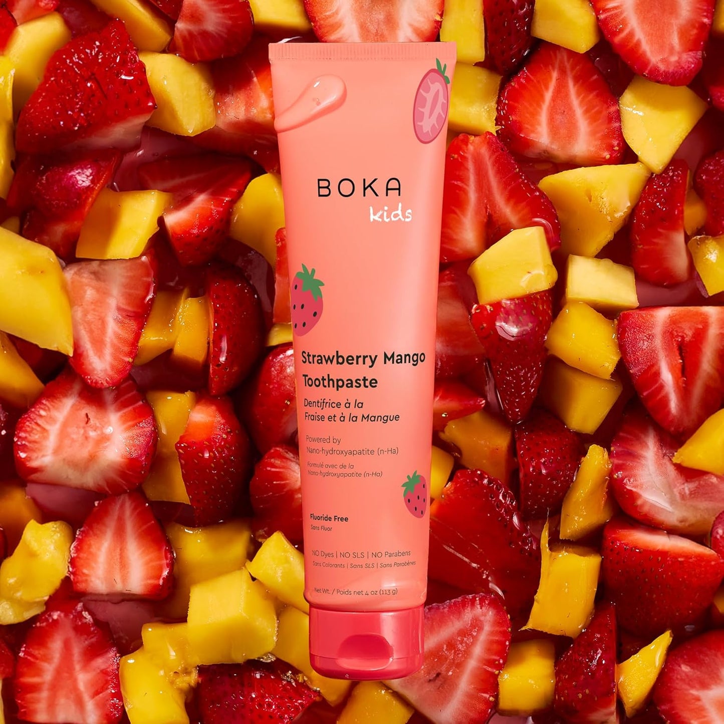 Boka Kids Strawberry Mango Toothpaste tube surrounded by sliced strawberries and mangoes.