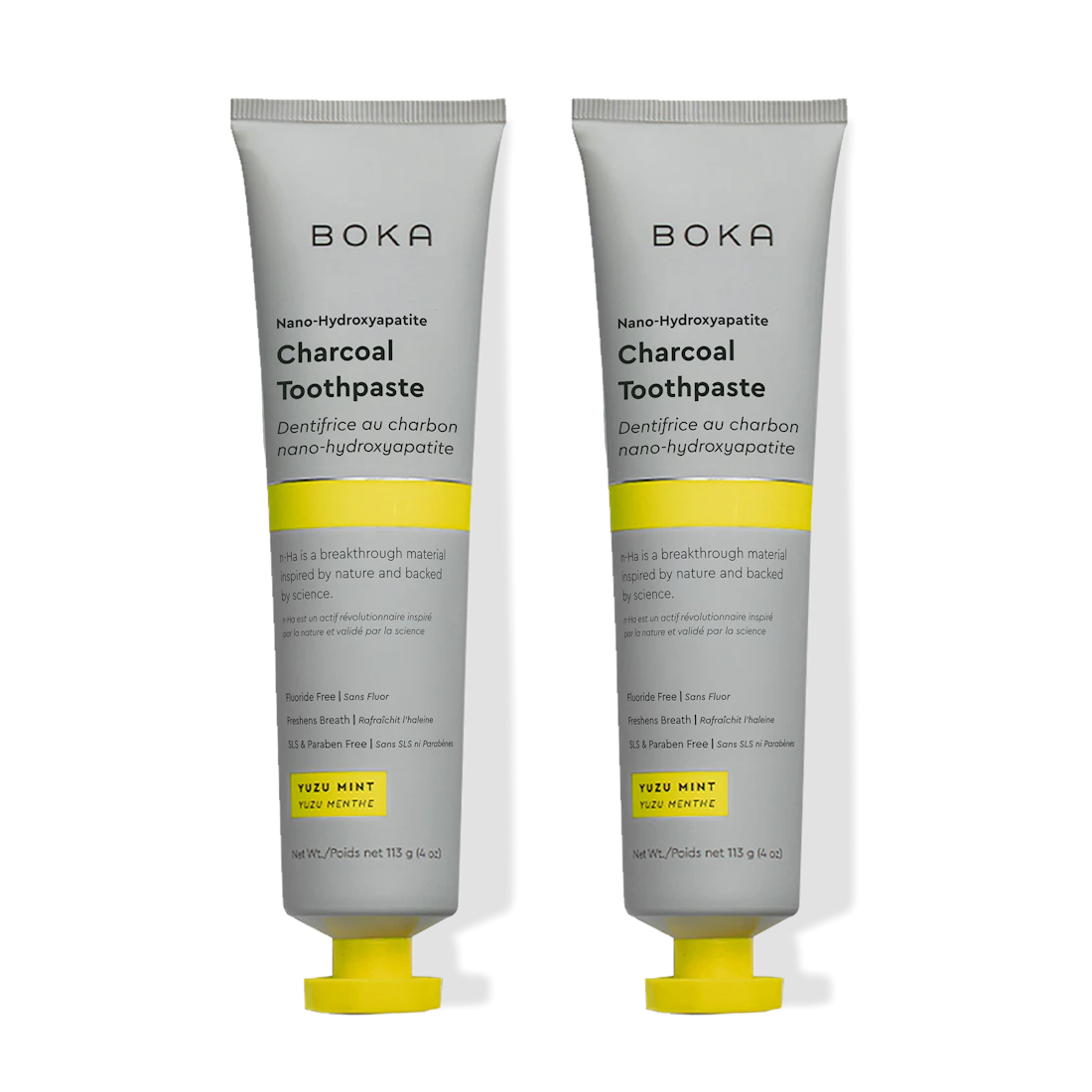 Two tubes of Charcoal Yuzu Mint n-Ha Toothpaste stand upright on a plain background.