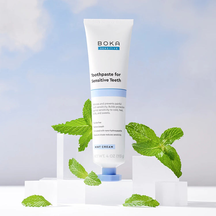 Boka toothpaste for sensitive teeth with mint leaves on a light blue background