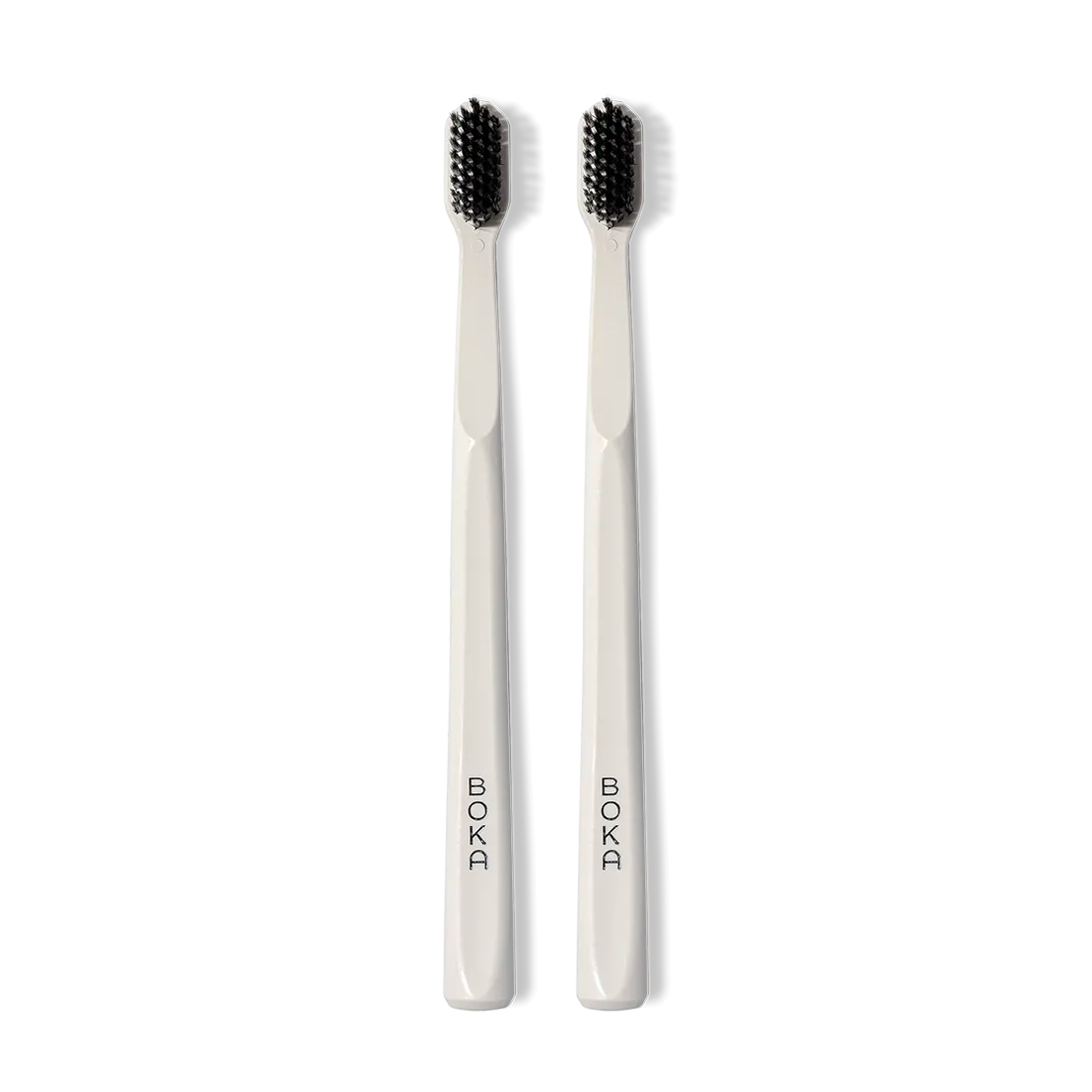 Classic Toothbrush 2-Pack: two white brushes with charcoal bristles for a gentle clean, upright.