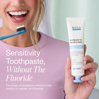Person holding a tube of Boka toothpaste for sensitive teeth with text about sensitivity toothpaste without fluoride.