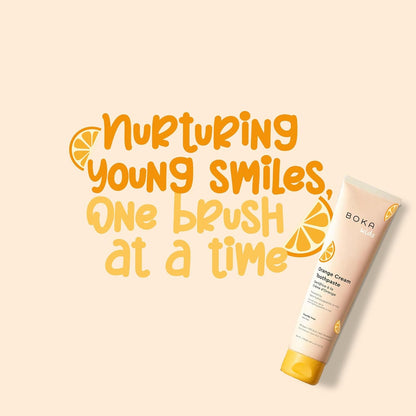 Boka Orange Cream toothpaste tube with text 'Nurturing young smiles, one brush at a time' on a beige background