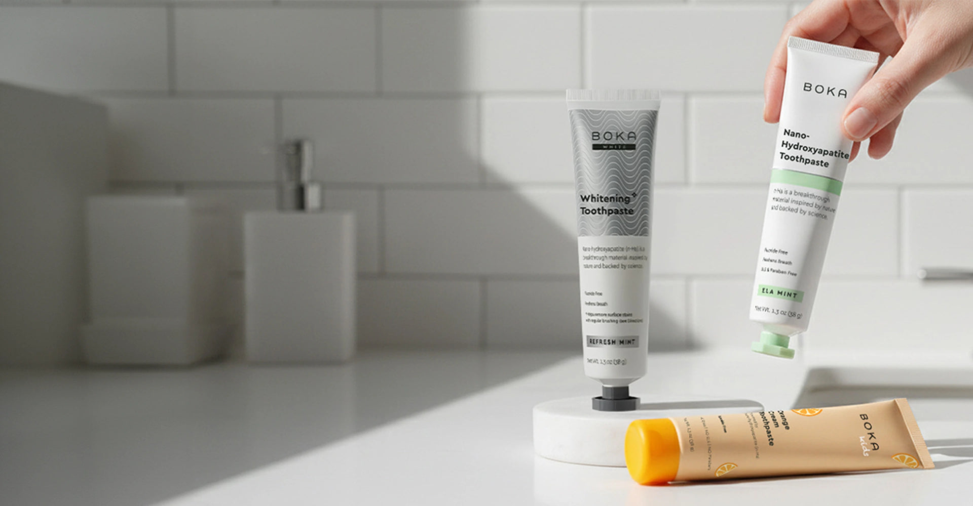 Boka toothpaste tubes on a bathroom counter with a blurred background
