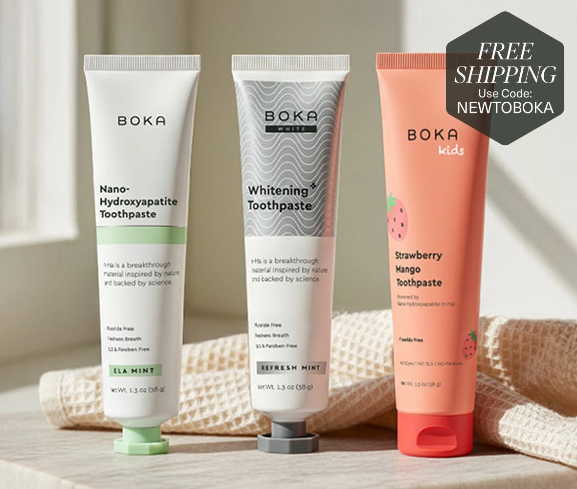 Three Boka toothpaste tubes on a wooden surface.