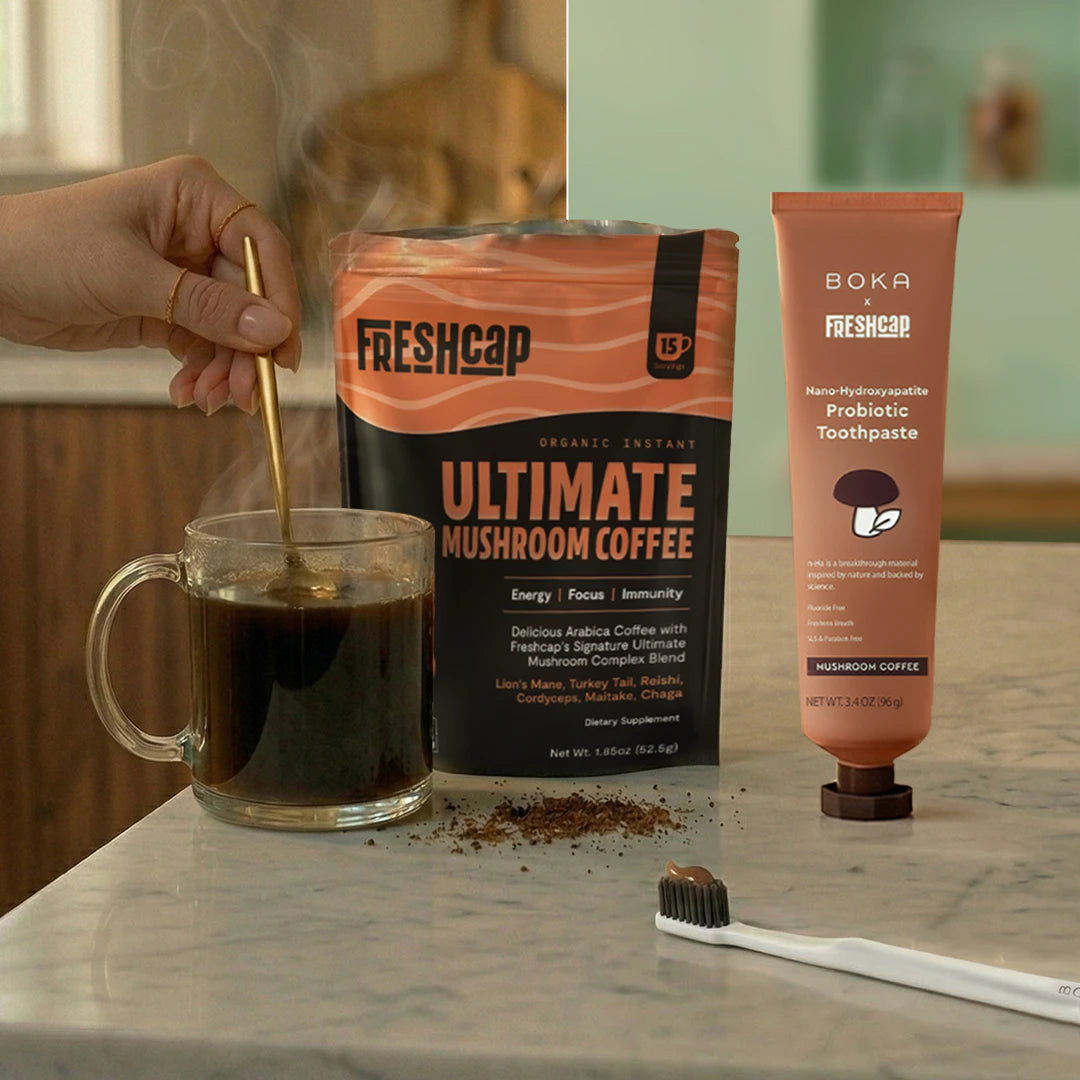 Freshcap Ultimate Mushroom Coffee with a cup of coffee, toothpaste, and toothbrush on a marble surface.