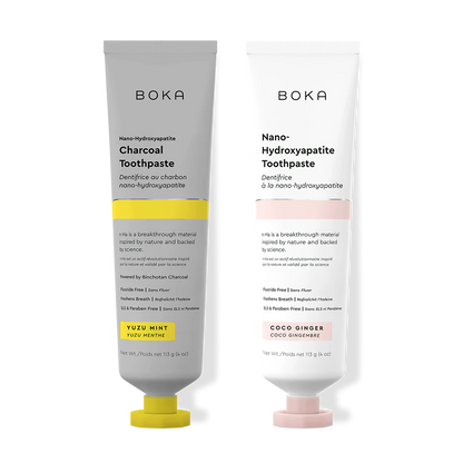 Two Boka toothpaste tubes, one with charcoal flavor and the other with coco ginger flavor, on a white background.