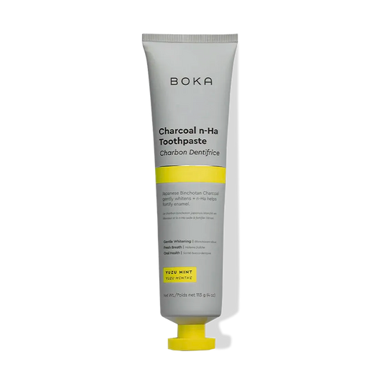 A tube of Charcoal Yuzu Mint Whitening n-Ha Toothpaste with yellow and gray labeling, upright.