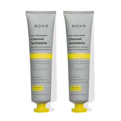 Two tubes of Charcoal Yuzu Mint n-Ha Toothpaste stand upright on a plain background.