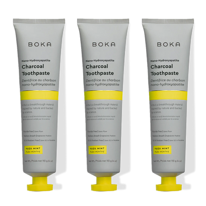 Three tubes of Boka Charcoal Toothpaste with yellow accents on a white background