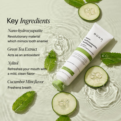 Boka Cucumber Mint toothpaste tube lying on rippling water surrounded by fresh cucumber slices and mint leaves. On the left side, text lists key ingredients: nano-hydroxyapatite, green tea extract, xylitol, and cucumber mint flavor.