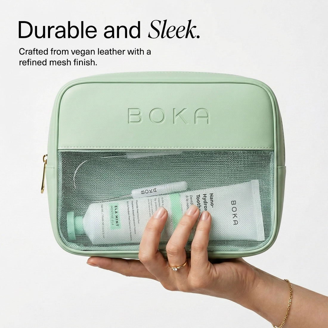 Mint green toiletry bag with 'Boka' branding, holding skincare products, on a white background.