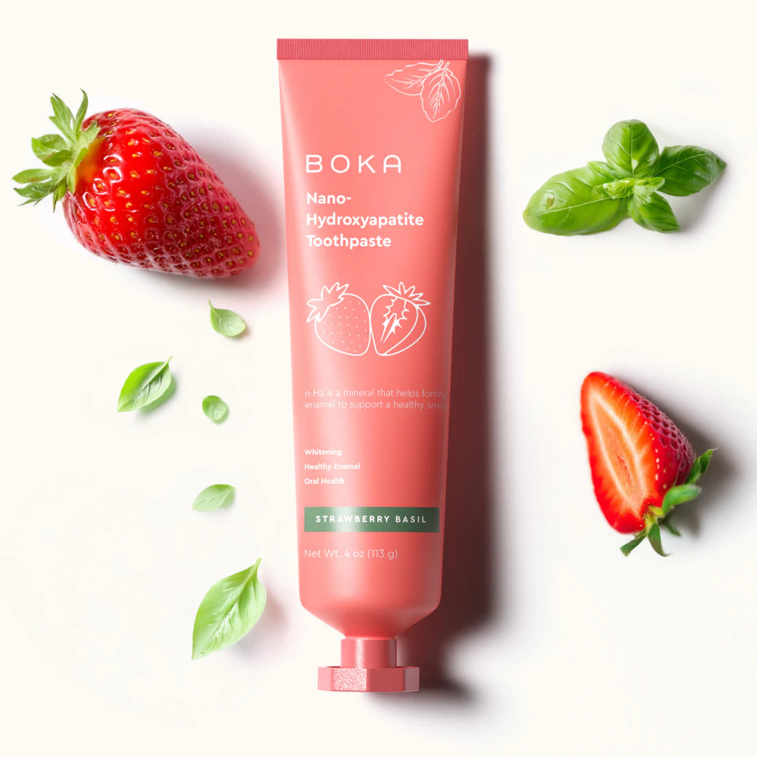 A pink tube of Strawberry Basil n-Ha Toothpaste, fluoride-free with strawberries and basil leaves.
