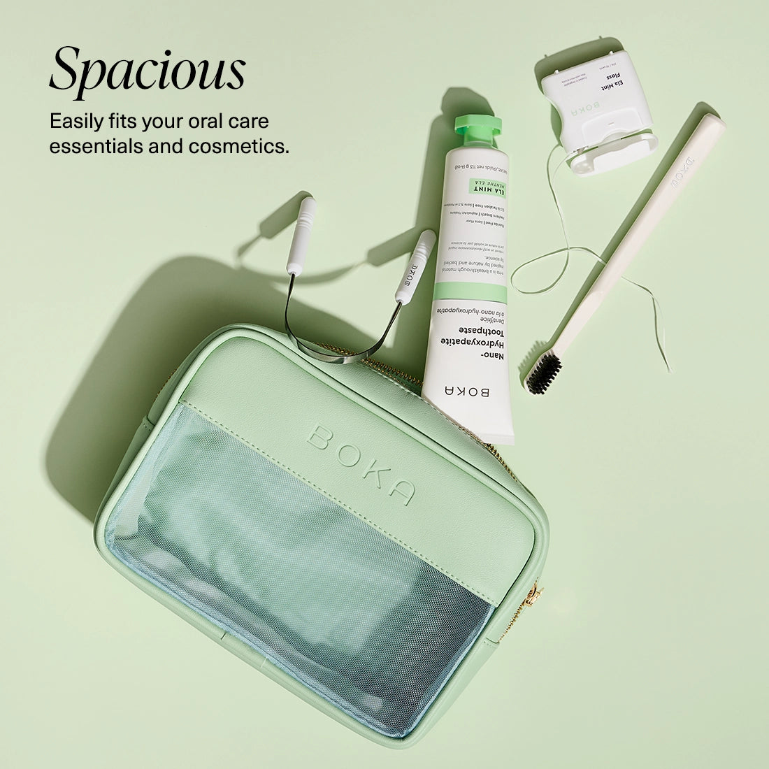 Green cosmetic bag with oral care products on a light green background