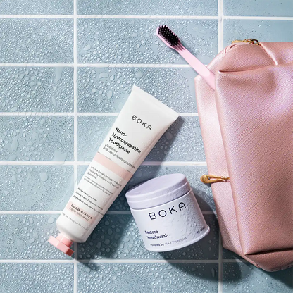 Boka toothpaste and mouthwash with a pink bag on a tiled surface