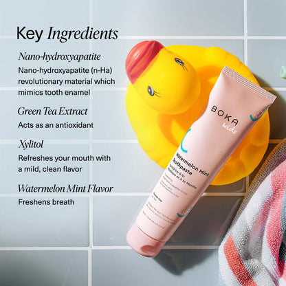 Boka Watermelon Mint toothpaste tube and toothbrush on a textured towel with mint leaves, alongside key ingredients listed