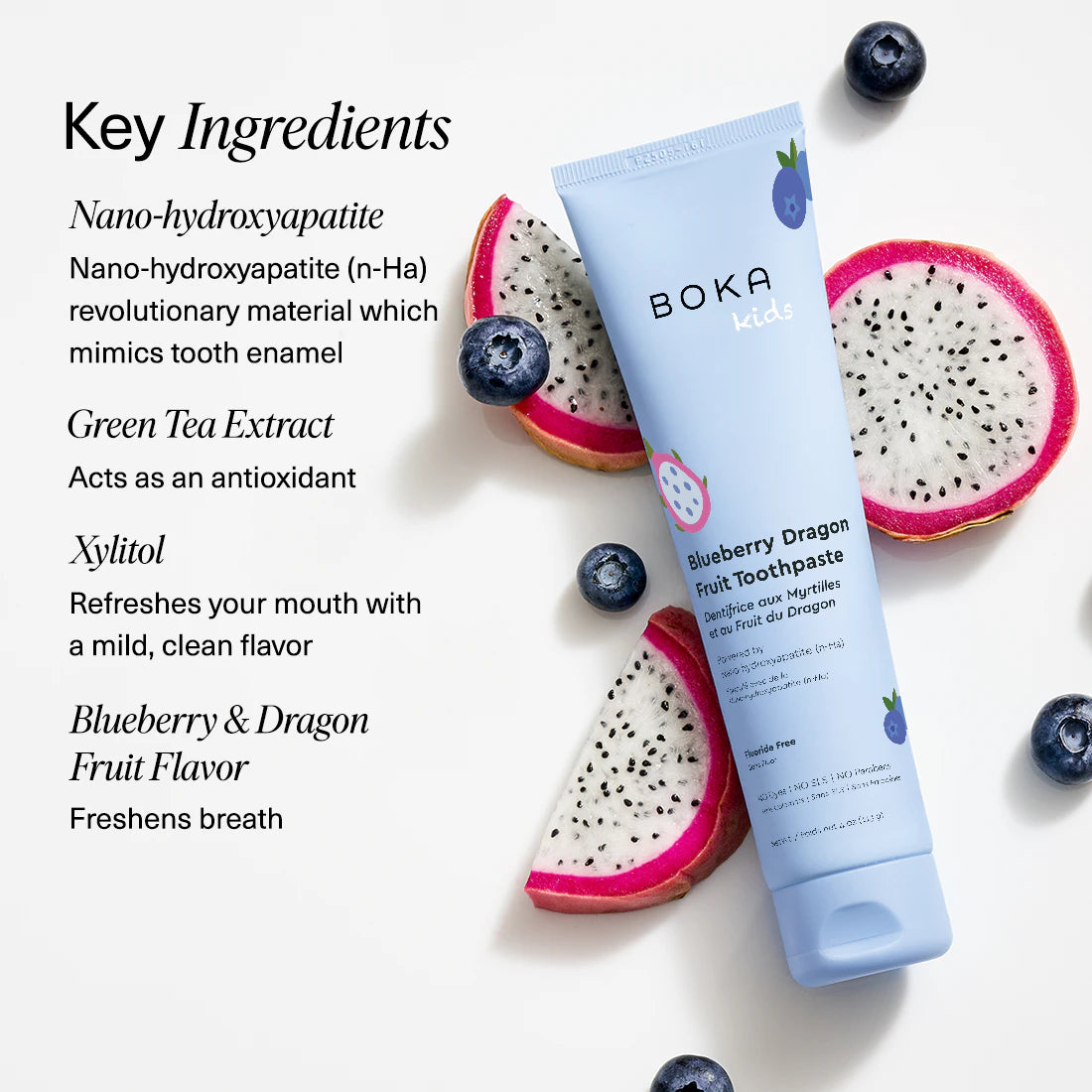 Boka Blueberry Dragon Fruit toothpaste tube and toothbrush on a textured towel with mint leaves, alongside key ingredients listed