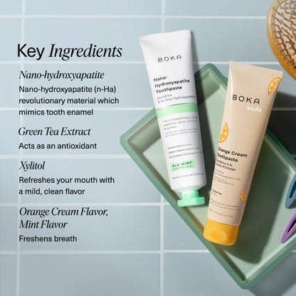 Boka toothpaste tubes on a textured towel with mint leaves, alongside key ingredients listed