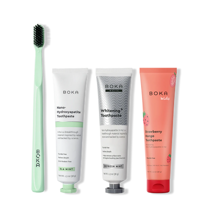 Collection of Boka toothpaste and a toothbrush on a white background