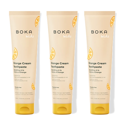 Three tubes of Boka Kids Orange Cream Toothpaste on a white background