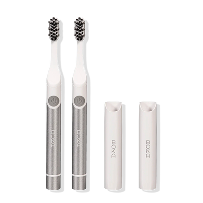 Two Boka Pocket Electric Toothbrushes with Sonic Pulse Technology and white caps on white.
