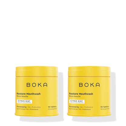 Two yellow containers of Boka Restore Mouthwash on a white background