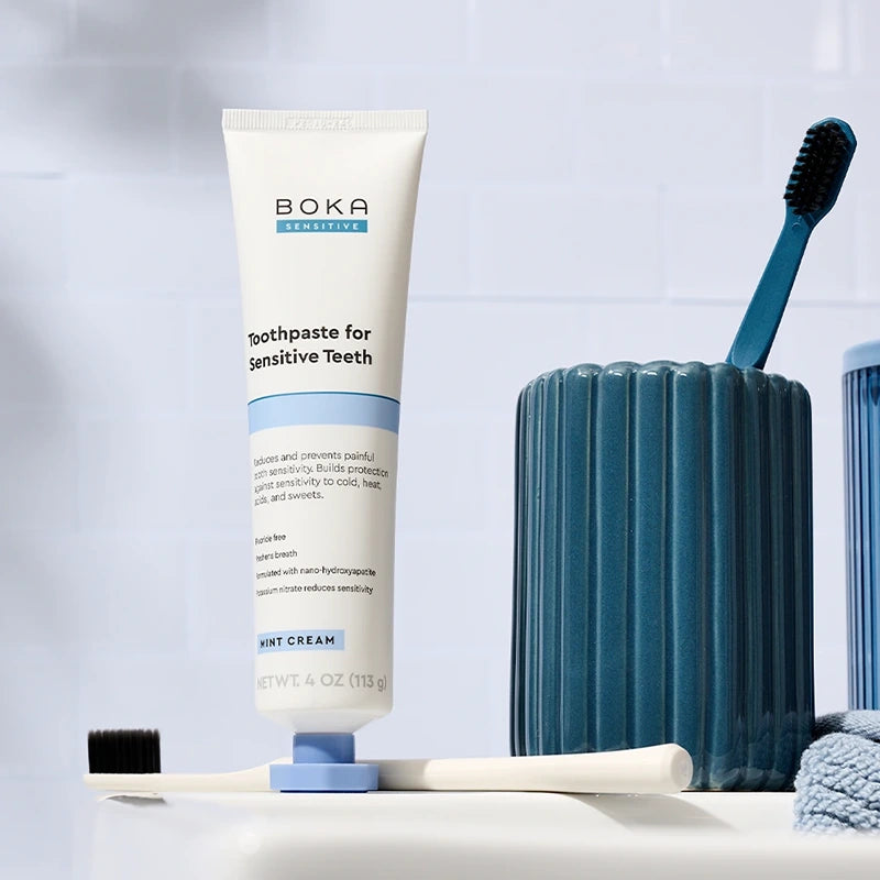 Boka toothpaste for sensitive teeth with a toothbrush and toothpaste holder on a light background