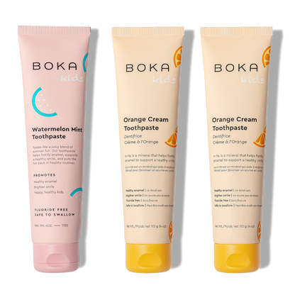 Three tubes of Boka toothpaste, two in orange cream flavor and one in watermelon mint flavor, on a white background.