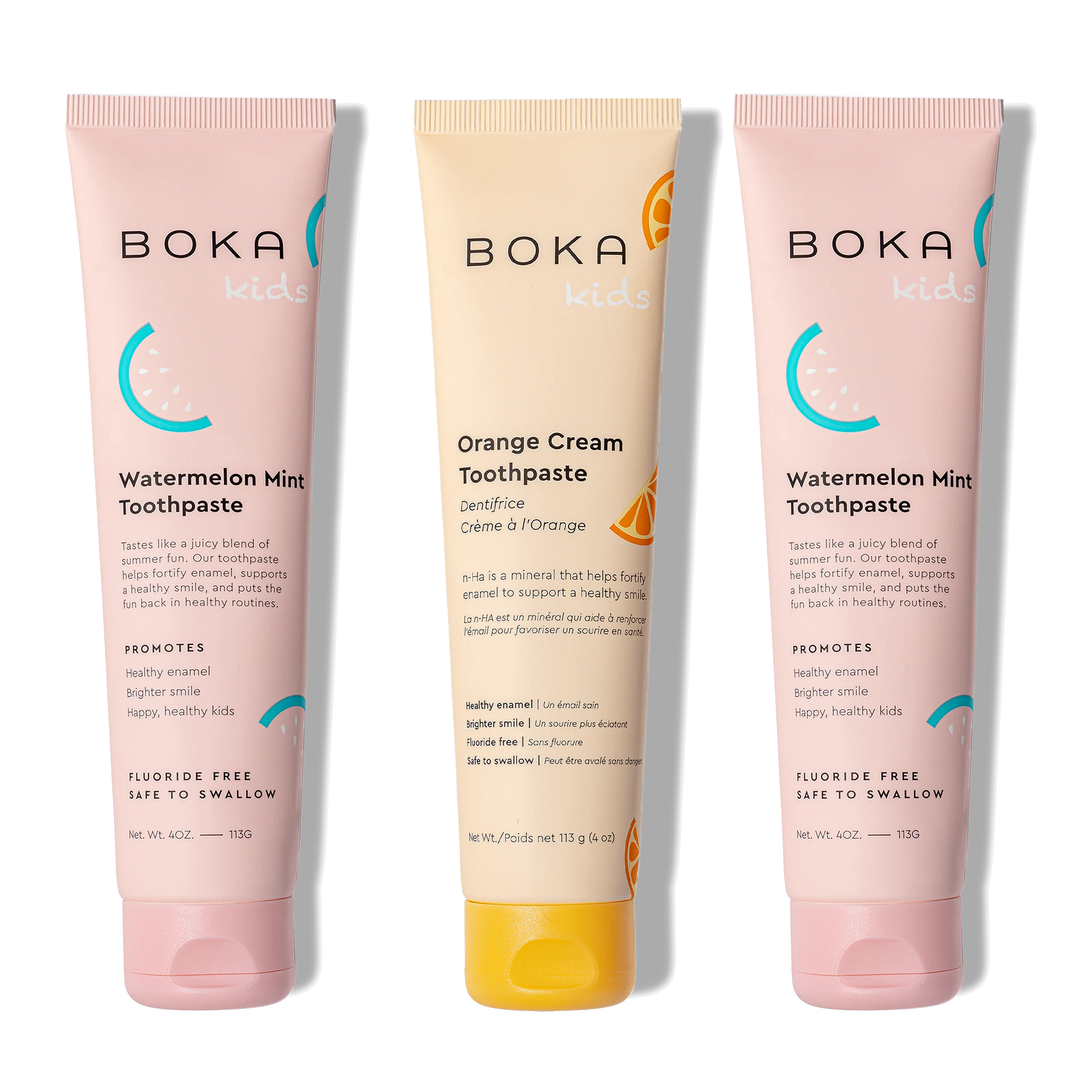 Three tubes of Boka toothpaste, two pink and one orange, on a white background.