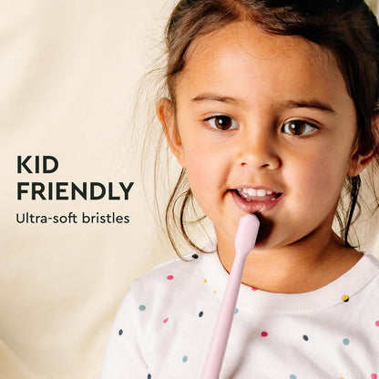 Young child holding a Classic Toothbrush 2-Pack: gentle clean, ultra-soft bristles, activated charcoal.